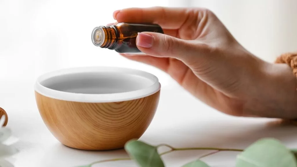 Pessoa colocando óleo em difusor.