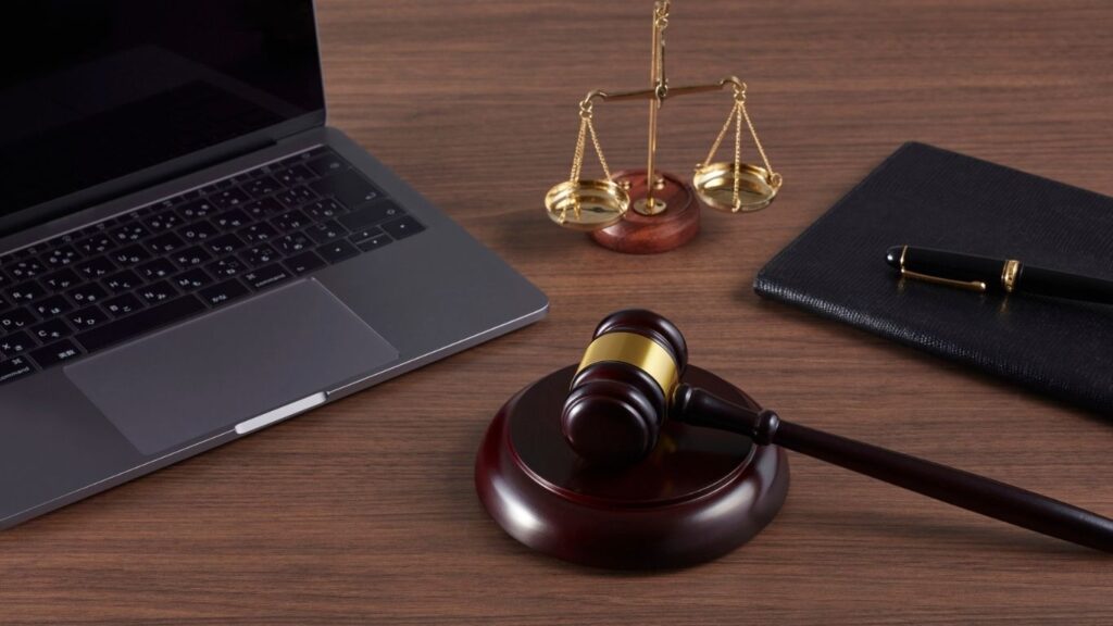 Aromas para escritório de advocacia: mesa com notebook, martelo de juiz e o símbolo do direito com as duas balanças