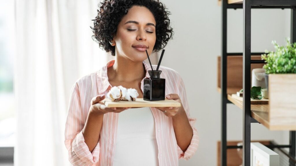 mulher sentindo aroma de difusor.