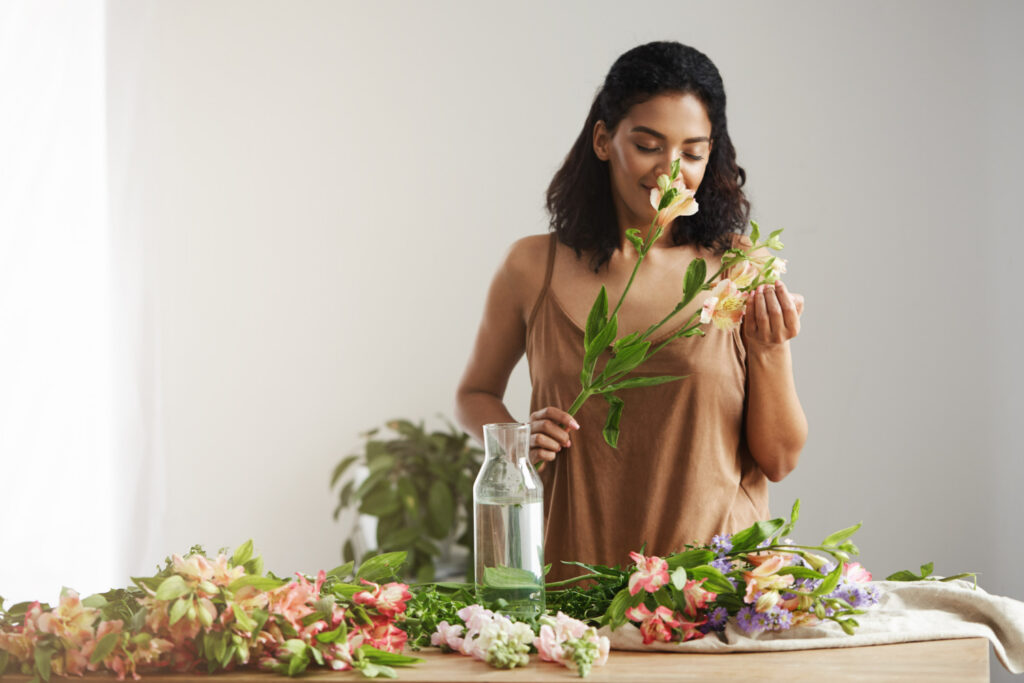 fragrâncias florais: mulher cheirando planta